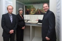 Gerhard Vitek, Direktor des Mozarthauses, Sylvia Mattl-Wurm, Direktorin der Wienbibliothek, Thomas Aigner, Leiter der Musiksammlung. Foto: Presse- und Informationsdienst Farbfoto: Frau und zwei Männer stehen vor Vitrine mit einer Notenhandschrift und einem Gemälde
