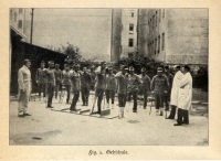 Gehschule für Kriegsinvalide im Kriegsspital Ottakring (1915), Wienbibliothek im Rathaus in einem Hof machen Männer mit Beinprothesen und Krücken Übungen unter Aufsicht von Ärzten