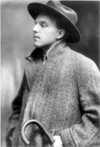 Ernst Krenek. Foto: Wien Museum Schwarz-Weiß-Photographie: junger Mann mit Hut, Mantel und Spazierstock