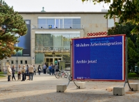 50 Jahre Arbeitsmigration. Archiv jetzt! Farbphotographie: Plakatwand vor Museum