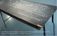 Farbphotographie: abgenutzter dunkelbrauner Tisch mit weißer Schrift