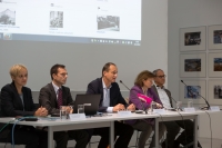 Zwei Frauen, drei Männer auf Podium; Leinwand zeigt Wien Geschichte Wiki.